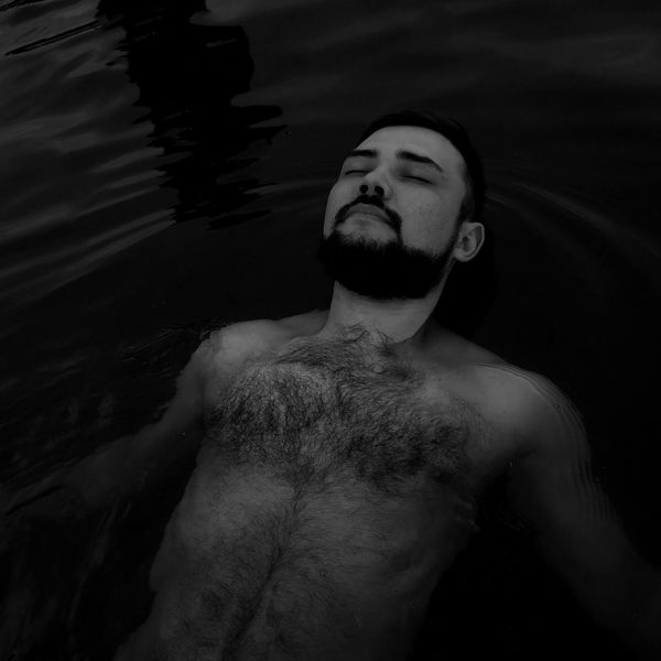 Person meditating peacefully in a minimalist setting with soft lighting.